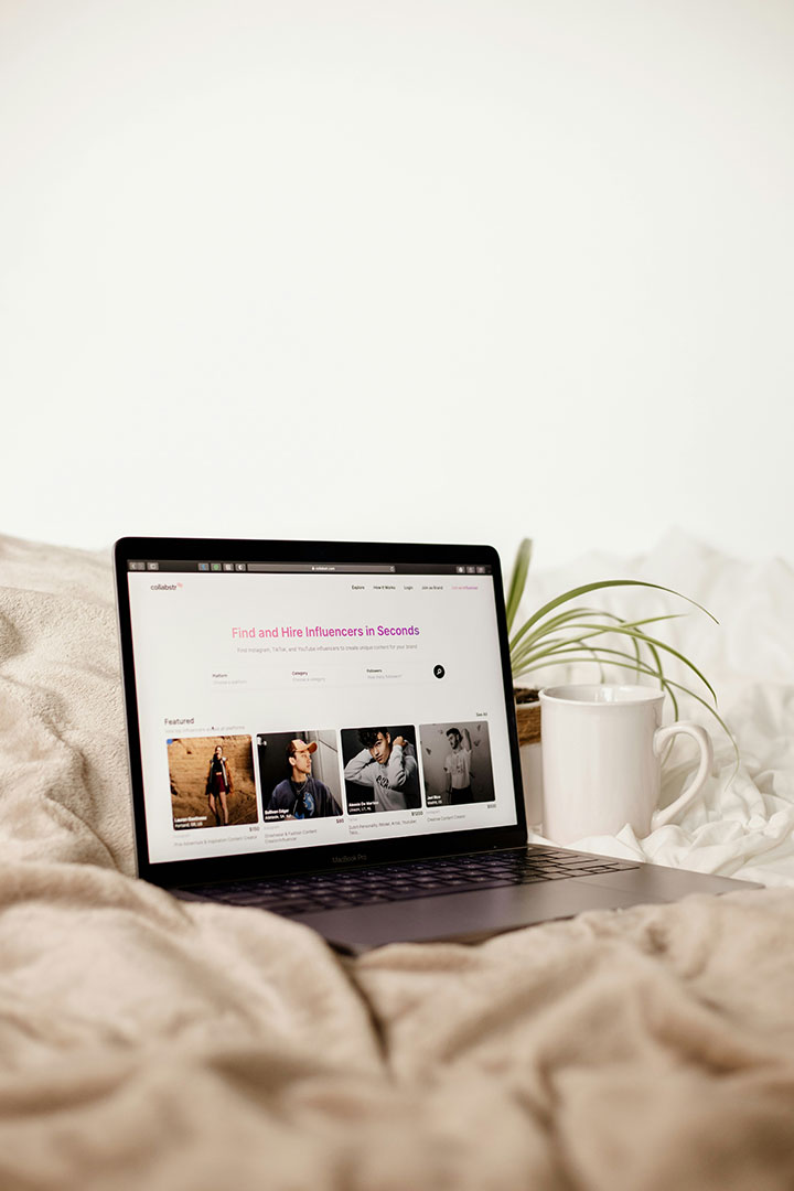 A laptop on a blanket open to a page advertising finding an influencer.