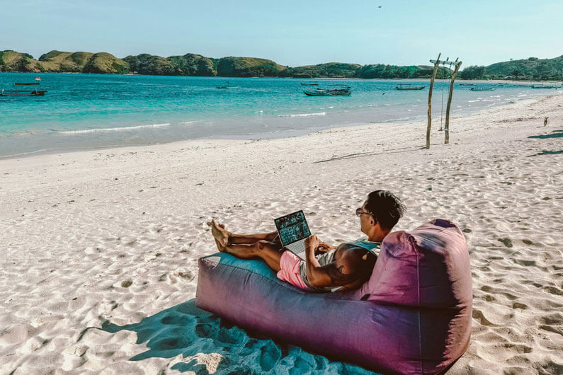 Man working on the beach with his laptop