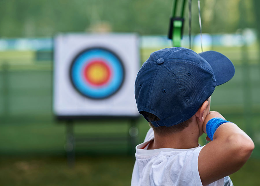 POV behind an archer aiming for a target.