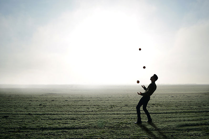 A juggler performing in a field.